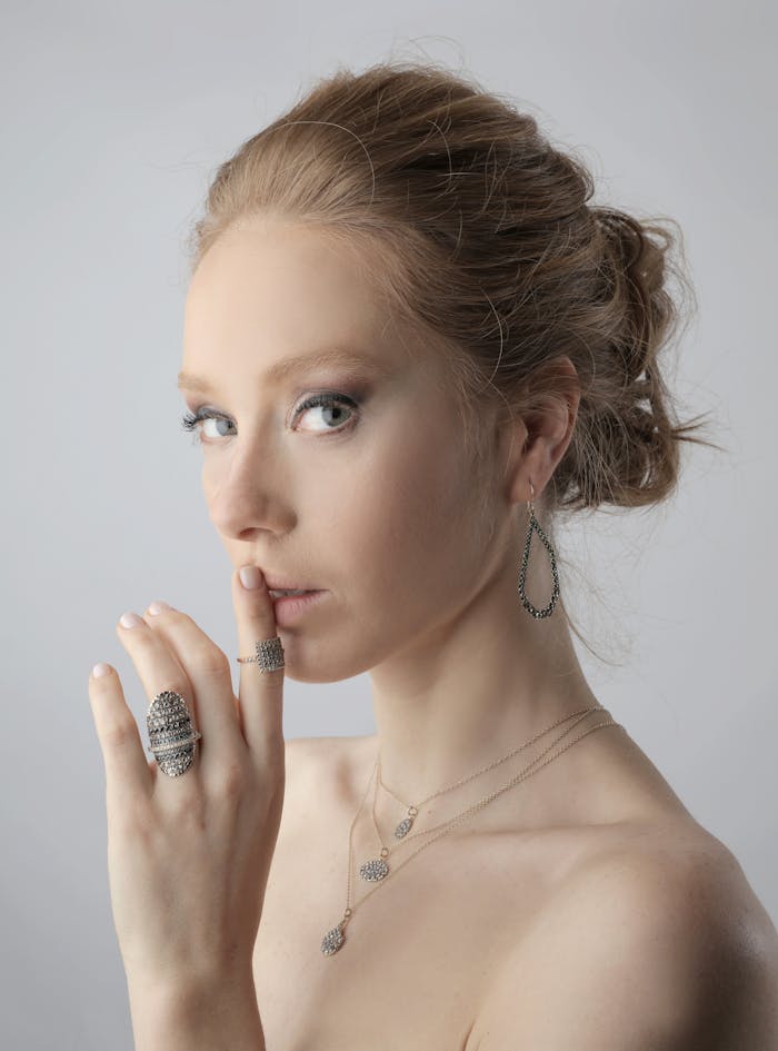 Portrait of an elegant woman with jewelry in a pose of quiet contemplation, showcasing fashion and beauty.